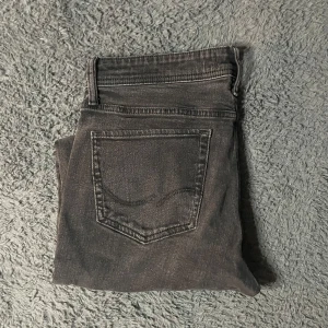Jack & Jones Glenn jeans  - Snygga svarta slim jeans med klassisk femficksdesign. De har en modern look och är perfekta för en stilren outfit. Midjan är normal och de har en dragkedja framtill.