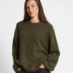 Olivgrön stickad tröja - Mysig olivgrön stickad tröja med rund hals och långa ärmar. Perfekt för kyliga dagar med sin avslappnade passform och mjuka material. Enkelt att matcha med jeans eller kjol för en stilren look. Använd fåtal gånger, dock blivit nopprig pga billigt material . 