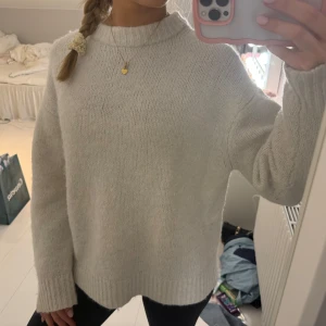 Vit stickad tröja - Mysig vit stickad tröja med långa ärmar och en avslappnad passform. Perfekt för kyligare dagar och enkel att matcha med olika outfits.