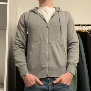 Grå hoodie med dragkedja från jack n jones - Säljer en stilren grå hoodie med dragkedja och huva. Perfekt för en avslappnad look.storlwk xs och skicket är bra🌟 hör av dig vid någon fråga!