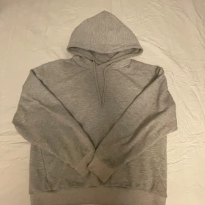 Grå hoodie - Säljer en klassisk grå hoodie med luva och långa ärmar. stor i storleken inga tecken på användning.