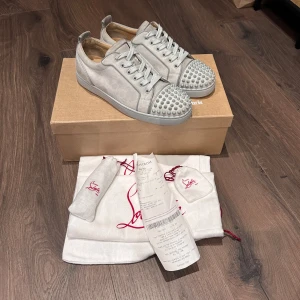 Christian Louboutin Skor  - Gråa Loubs i nästintill nyskick, lite limrester på höger sko som syns i bilderna, märks inte av vid användning! Storlek 41 fits 41,5-42, all og dvs box, dustbags, extra snören & spikar samt kvitto! Nypris 9500 mitt pris 4000 men tar emot rimliga bud! Över 200 deals gjorda med massvis av recensioner att visa vid intresse!