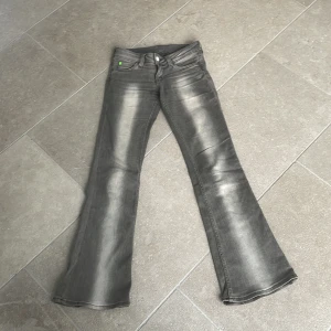 Grå bootcut jeans från Cheap Monday - Snygga grå bootcut jeans från Cheap Monday med en cool tvättad look. De har en klassisk femficksdesign och en bekväm passform. Perfekta för en avslappnad stil.