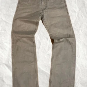 Beige byxor från Diesel - Snygga beige byxor från Diesel i modellen Viker-R-Box. De har en klassisk design med raka ben och en normal passform. Perfekta för en stilren look.