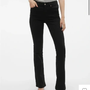 Svarta bootcut jeans - Snygga svarta bootcut jeans med medelhög midja. Perfekta för en stilren look. De har en klassisk design med knappar och dragkedja framtill. Storleken är S/32 och jag är 170, dem är lite lite korta för mig 
