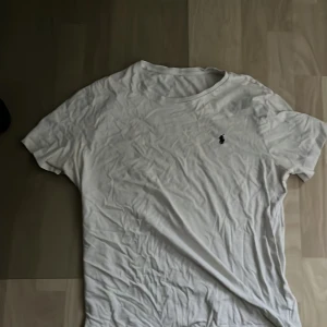 Vit t-shirt från Ralph Lauren - Säljer en klassisk vit t-shirt från Ralph Lauren med korta ärmar och en broderad logga på bröstet. Perfekt för en stilren och avslappnad look.