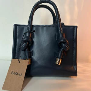 Handväska med knutdetaljer - Snygg marinblå handväska från Zara, köpt på Sellpy. Själv aldrig använt. 