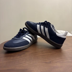 Adidas Samba marinblå sneakers - Här är ett par stilrena blåa Adidas Samba. Skorna är sprillans nya och använt de 1 gång då skorna är för stora. Storlek 41, men modellen är ganska stor så funkar för 41,5. Priset går såklart att diskutera, bara höra av dig!