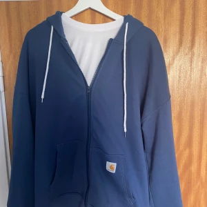 Blå Carhartt hoodie med dragkedja - Säljer en blå zip hoodie från carhartt. Väldigt bra skick använd ett tiotal gånger. Storlek L. Priset kan diskuteras, hör av er vid flera frågor.