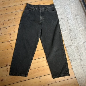 Svarta/bruna wide jeans - Säljer ett par svarta jeans från COS med bred passform. Jeansen har klassisk femficksdesign, raka ben och är tillverkade i kraftig denim. Perfekta för dig som gillar en avslappnad och trendig look. Använda 3 gånger