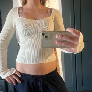 Ribbad ljusbeige långärmad topp Gina Tricot - Supersnygg ribbad topp i ljusbeige från Gina Tricot. Den har lång ärm, fyrkantig ringning och figurnära passform. Perfekt att styla med jeans eller kjol för en clean look.