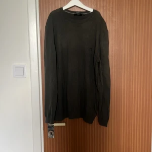 Mörkgrön stickad tröja från Hugo Boss - Snygg mörkgrön stickad tröja från Hugo Boss i storlek M. Tröjan har rund hals, långa ärmar och diskret BOSS-logga på bröstet. Tillverkad av fin italiensk garn för en mjuk och skön känsla. Perfekt för dig som gillar stilrena och klassiska plagg.