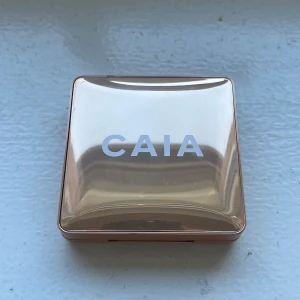 CAIA highlighter - Saint Tropez - Skicka prisförslag!!         Snygg highlighter från CAIA i en lyxig, spegelblank guldig dosa. Pudret har en skimrande champagnefärg och är pressat i ett cirkelmönster. Perfekt för att ge glow till kindben, näsa och amorbåge. Endast testad vid ett tillfälle!