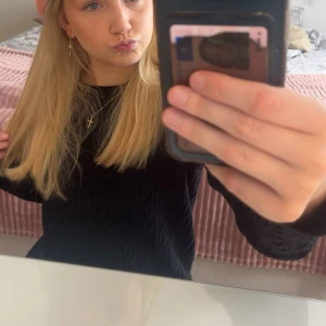 Svart kabelstickad tröja - Svart kabelstickad tröja med rund hals och långa ärmar. Tröjan har ett klassiskt flätmönster och är perfekt för lager-på-lager. Passar dig som gillar en enkel men ändå snygg stil.