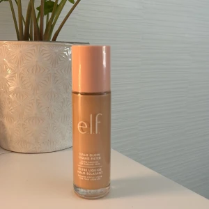 e.l.f. Halo Glow Liquid Filter - Halo Glow liquid filter i nyansen Shade 2 Fair/Light. Kommer i en glasflaska med persikofärgat lock och stor applikator. Ger en snygg, strålande finish och kan användas ensam eller under foundation för extra lyster. Ungefär lite mer än hälften kvar av den! PRIS GÅR ATT DISKUTERA