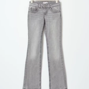 Grå bootcut jeans från Gina  - Snygga grå jeans från Cubus med bootcut passform och klassisk femficksdesign. Jeansen har en ljusgrå tvätt och är tillverkade i mjukt denim-material med knapp och dragkedja framtill. Perfekta för dig som gillar en retro vibe och vill ha lite extra sväng på benen. Skriv för egna bilder ❤️är lite små i storleken ❤️