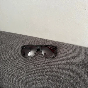 Rayban boyfriend liknande - Snygga svarta solglasögon  med fyrkantig form och mörka tonade glas. Ramen är i svart plast med diskret logga på sidan. Perfekta för att ge en cool vibe till din outfit.