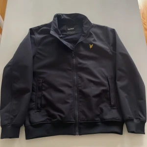 Mörkblå vindjacka från Lyle & Scott L - Mörkblå jacka från Lyle & Scott i storlek L som passar perfekt till vår & höst. Ny pris från MQ 1500 mitt pris 800