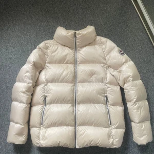 Beige pufferjacka från Colmar - Säljer nu denna populära jacka från Colmar. Perfekt nu till vintern. Den är i jättebra skick och bara använd några gånger. Jag köpte den på kidsbrandstore för ca 4500 kr. Den är i storlek 14 y/o men skulle mer säga en XS dam. Pris kan såklart diskuteras men eftersom den är eftertraktad kommer jag inte acceptera några skambud. Skriv för fler bilder. 