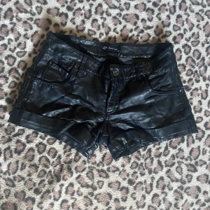 Svarta skinnshorts  - Coola svarta shorts i skinnlook från SisterS Point. Sliten vid rumpan.