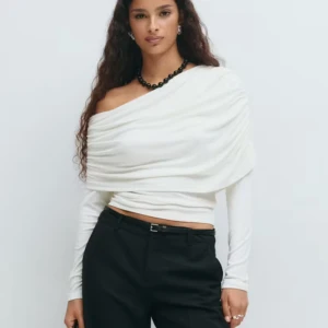 Vit oneshoulder topp med drapering - Säljer en vit långärmad topp med snygg drapering och oneshoulder-design. Toppen är från gina tricot, har en tight passform och är tillverkad i ett mjukt material som sitter skönt mot kroppen. Perfekt för dig som vill sticka ut med en cool och trendig look.