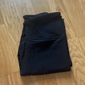 Svarta ribbade leggings från SOC  - Säljer ett par svarta ribbade leggings från SOC i storlek XS. De har hög midja med snygg V-formad linning och är gjorda i ett stretchigt, tekniskt material som andas. Perfekta för träning eller chill dagar. Supersköna och sitter riktigt bra! Köptes nyligen
