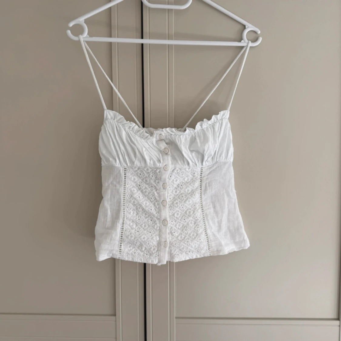 Vit broderad linnetopp med knappar