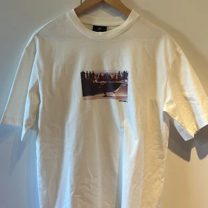 Vit loose fit t-shirt med skateprint H&M !! - Vit t-shirt från H&M i loose fit med ett färgstarkt skatefoto tryckt på bröstet och texten 'PASSION' i graffiti-stil. Klassisk rund hals och korta ärmar !! :)