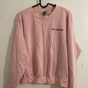 Rosa BLACKPINK sweatshirt från H&M - Säljer en oversized rosa sweatshirt från H&M x BLACKPINK. Tröjan har rund hals, långa ärmar och tryckt logga på bröstet. Mjuk insida och ribbade muddar. Perfekt för dig som gillar K-pop och vill ha en chill och snygg look.