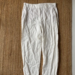 Vita linnebyxor från MNG - Säljer ett par vita linnebyxor från Mango i storlek S. Byxorna har hög mellan hög midja och är har kostm byxor passform. Tycker de varit lite korta för min smak därav säljer jag dom. 