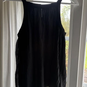 Svart ärmlös blus från Promod - Säljer en svart plisserad blus från promod i storlek s, som sitter superfint men inte kommer till användning.