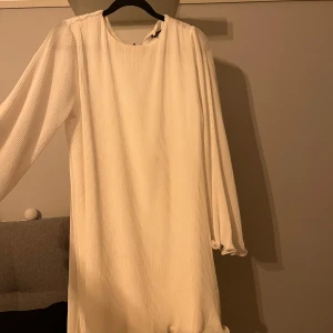 Vit klänning - Säljer en vit klänning med  långa vida ärmar. Strl xs men passar mig som har s. Skulle säga att den är som en s Kom med bud!