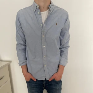 Ljusblå skjorta från Ralph Lauren - Klassisk ljusblå skjorta från Ralph Lauren. Skjortan är i otroligt bra skick. Nypris:1600kr mitt pris:299kr. Pris kan diskuteras vid snabb affär. 