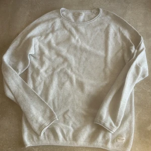 Ljusgrå långärmad tröja från Jack & Jones - Säljer en stilren ljusgrå långärmad tröja från Jack & Jones. Tröjan har rund halsringning och är tillverkad i ett mjukt, strukturerat material som känns bekvämt mot huden. Perfekt för lager-på-lager eller som den är.