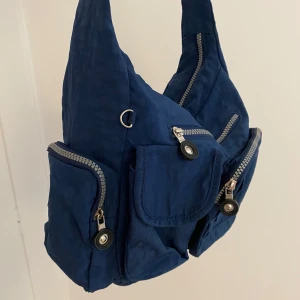 Blå axelväska - Marinblå axelväska med flera fickor med dragkedja. Passar dam, herr och unisex