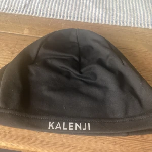 Svart träningsmössa från Kalenji - Svart, tunn och stretchig mössa från Kalenji, perfekt för löpning eller annan träning. Används aldrig, bra skick 