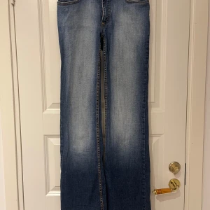 Blå bootcut jeans  - Säljer ett par klassiska blå bootcut med ljusare partier framtill och baktill. Jeansen har normal passform och femficksdesign. Perfekta för dig som gillar en avslappnad och tidlös stil. Så sköna och strechiga!