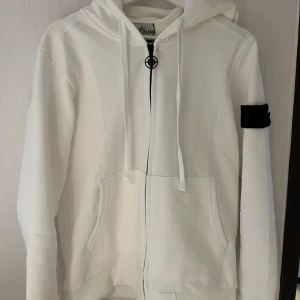 Vit hoodie från stone island  - 1•1Den är helt ny och oanvänd, de finns 2 olika badges och det finns en helsvart och den vanliga och dragkedjan har stoneisland märket också