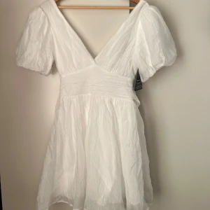 Studentklänning med rosett  - Säljer nu ännu en studentklänning som jag valt bort i de svåra valet om klänning. Klänningen är super fin men valt att gå för en annan långärmad istället😌 Hör av dig om du har några frågor!!  Helt slutsåld på Gina Tricot hemsida!!