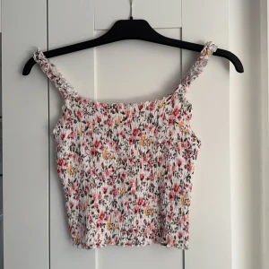 Blommig smockad linnetopp - Blommig top, aldrig använd prislappen sitter kvar. Storlek M😊