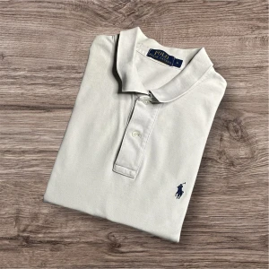 Ralph Lauren Piké - Ralph Lauren Piké – Vit (L)🤍  Säljer en stilren vit Ralph Lauren piké i storlek L. Klassisk modell som passar perfekt till både vardag och mer uppklädda tillfällen!  ✅ Storlek: L 📏 Mått: Längd 75 cm, armhåla till armhåla 55 cm, axel till axel 50 cm 🎨 Färg: Vit 🏷️ Märke: Ralph Lauren ⚠️ Billigt pris p.g.a. defekter på de två sista bilderna – men de syns inte när tröjan används!  📍 Finns för avhämtning i Linköping eller kan skickas mot fraktkostnad. Hör av dig vid intresse! 💬  102