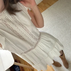 Vit klänning med spetsdetaljer - Säljer en söt vit klänning med volangärmar! Superfin nu till avslutningar och sommaren❣️