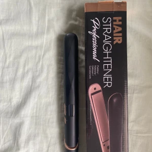 Svart och roséguld plattång - Snygg plattång i svart med detaljer i roséguld. Ergonomisk design med smala plattor och enkel knappkontroll på sidan. Passar för att styla och räta ut håret snabbt och smidigt. Levereras med originalförpackning.