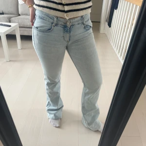 Ljusblå bootcut jeans - Säljer ett par ljusblå jeans med bootcut. Jeansen har normal passform och stängs med dragkedja och knapp. Perfekta till vardags för en avslappnad men snygg look.