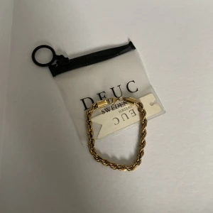 Cordell Guldarmband från DEUC Sweden - Säljer ett snyggt guldarmband från DEUC Sweden med tvinnad kedja. Armbandet har en klassisk karbinhake och kommer i originalförpackning med DEUC Sweden-tag. Perfekt accessoar för att lyfta din stil.