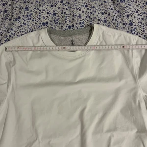 Vit basic t-shirt - En klassisk vit t-shirt med rund hals och korta ärmar. Perfekt för en clean och enkel stil. T-shirten är i ett mjukt material och har en normal passform.