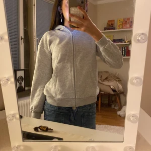 Grå hoodie med dragkedja - Säljer en enkel och stilren grå hoodie med dragkedja och luva. Tröjan har långa ärmar, fickor framtill. 💕