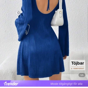 Blå ribbad kortklänning med öppen rygg - Supersnygg blå kortklänning med ribbad struktur och lång ärm. Klänningen har en öppen rygg med knytband upptill och lätt utsvängda ärmar. 