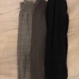 3-pack rutiga och mönstrade kostymbyxor - Säljer tre par kostymbyxor i olika grå och svarta toner. Storlek 30-31 sitter som XS. Relativt fina men använda! Hör av er vid frågor och intresse!