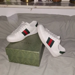Gucci ace - Trendiga gucci ace skor som passar perfekt inför sommaren. Skorna kommer med og låda och papper. Nypris är 8400 kr men mitt pris är 1899 kr. Skorna har inga defekter och är nästan så gott som nya. Hör gärna av dig om du har frågor och priset är ej hugget i sten.